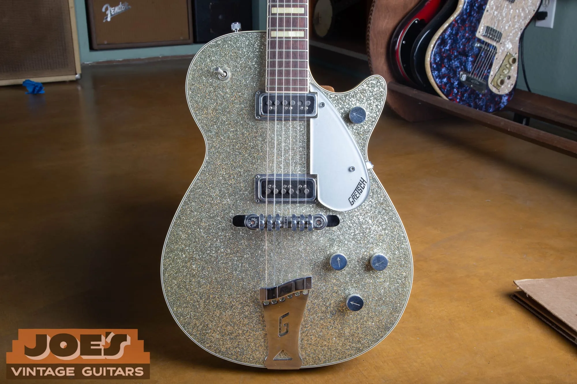 Front of a mid-1950s Gretsch Silver Jet 6129 with a silver sparkle top, DeArmond pickups, a Melita bridge, and a G-cutout tailpiece.
