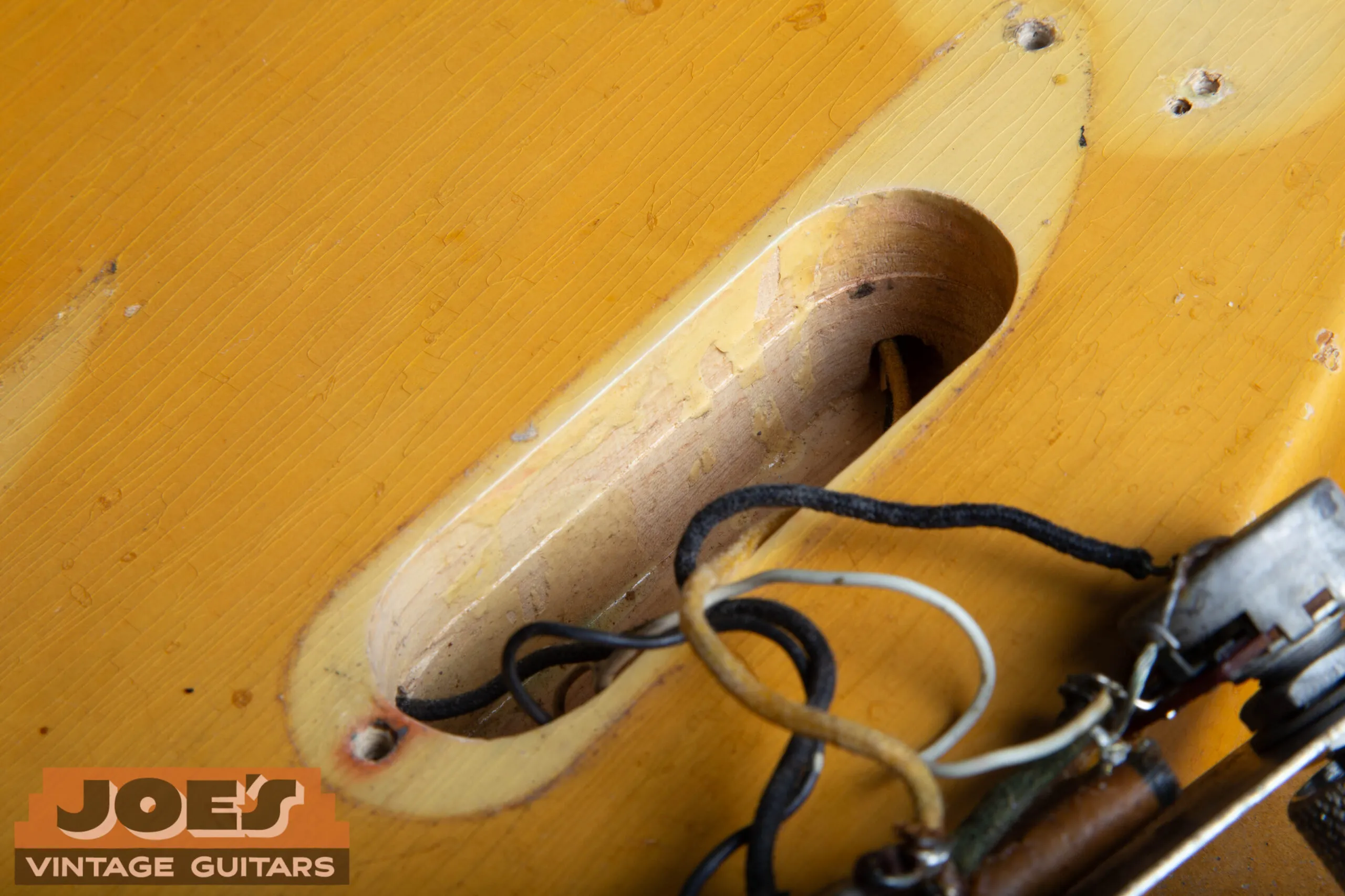Hand-router tool marks and slight step visible on the control cavity walls of a 1952 Fender Precision Bass