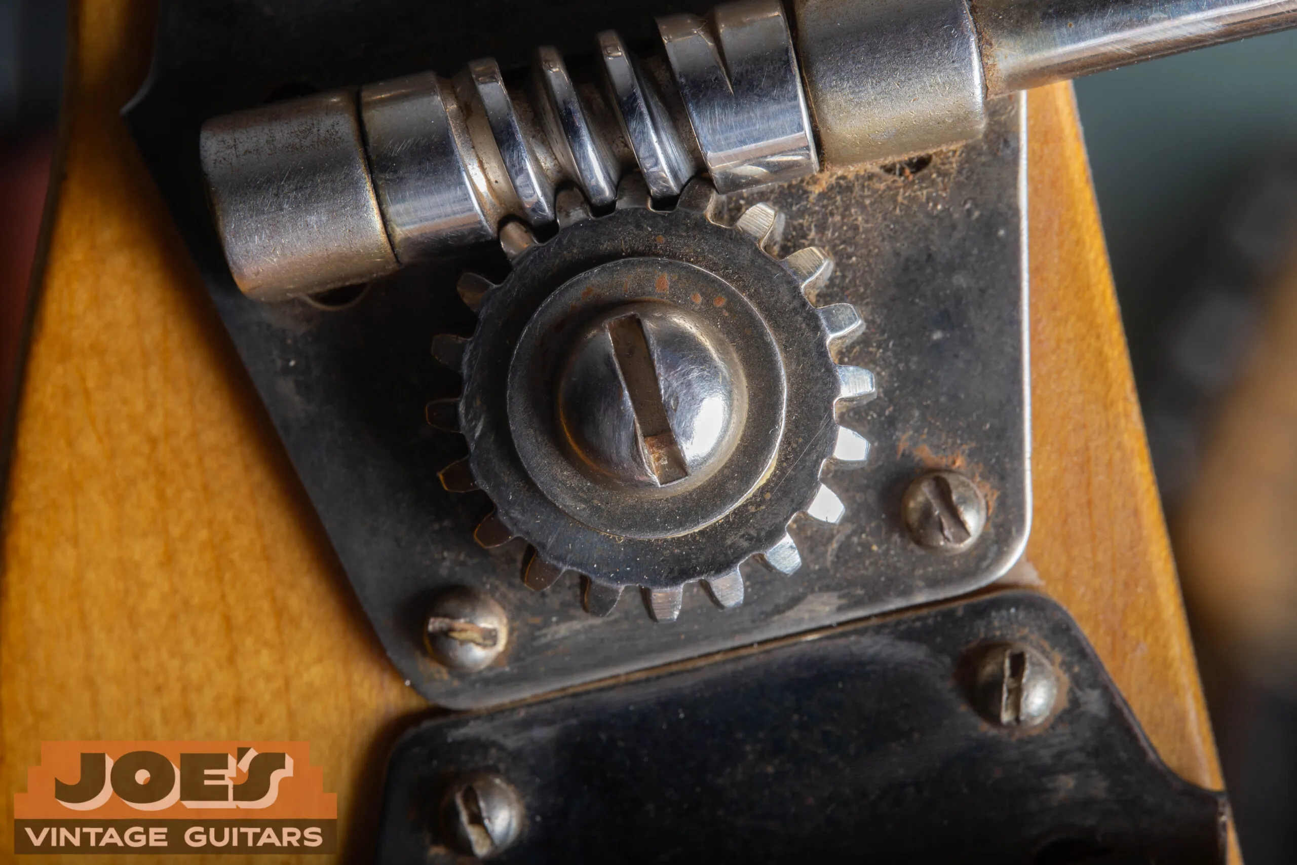 Original open-gear tuning machine on a 1952 Fender Precision Bass showing large flat metal button and four slotted mounting screws