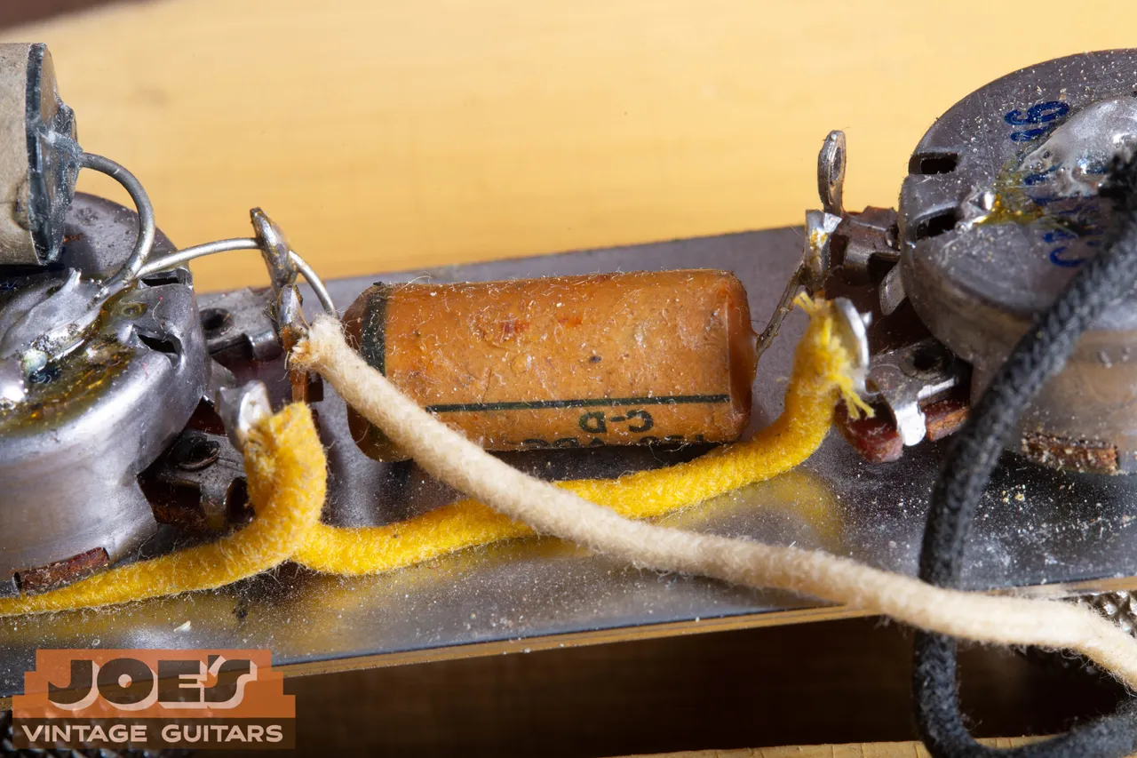 The tubular Cornell Dubilier waxed paper capacitor in a 1952 Fender Telecaster, marked C-D, with yellow and white cloth wire