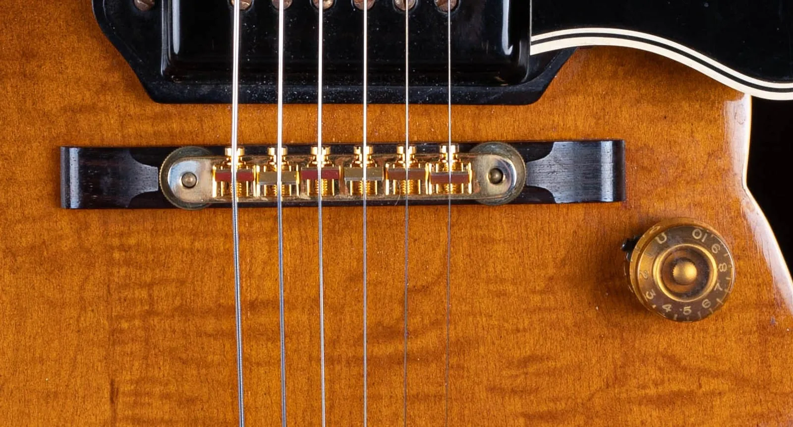 The upgraded gold tune-o-matic bridge on a rosewood base on a 1953 Gibson ES-5.
