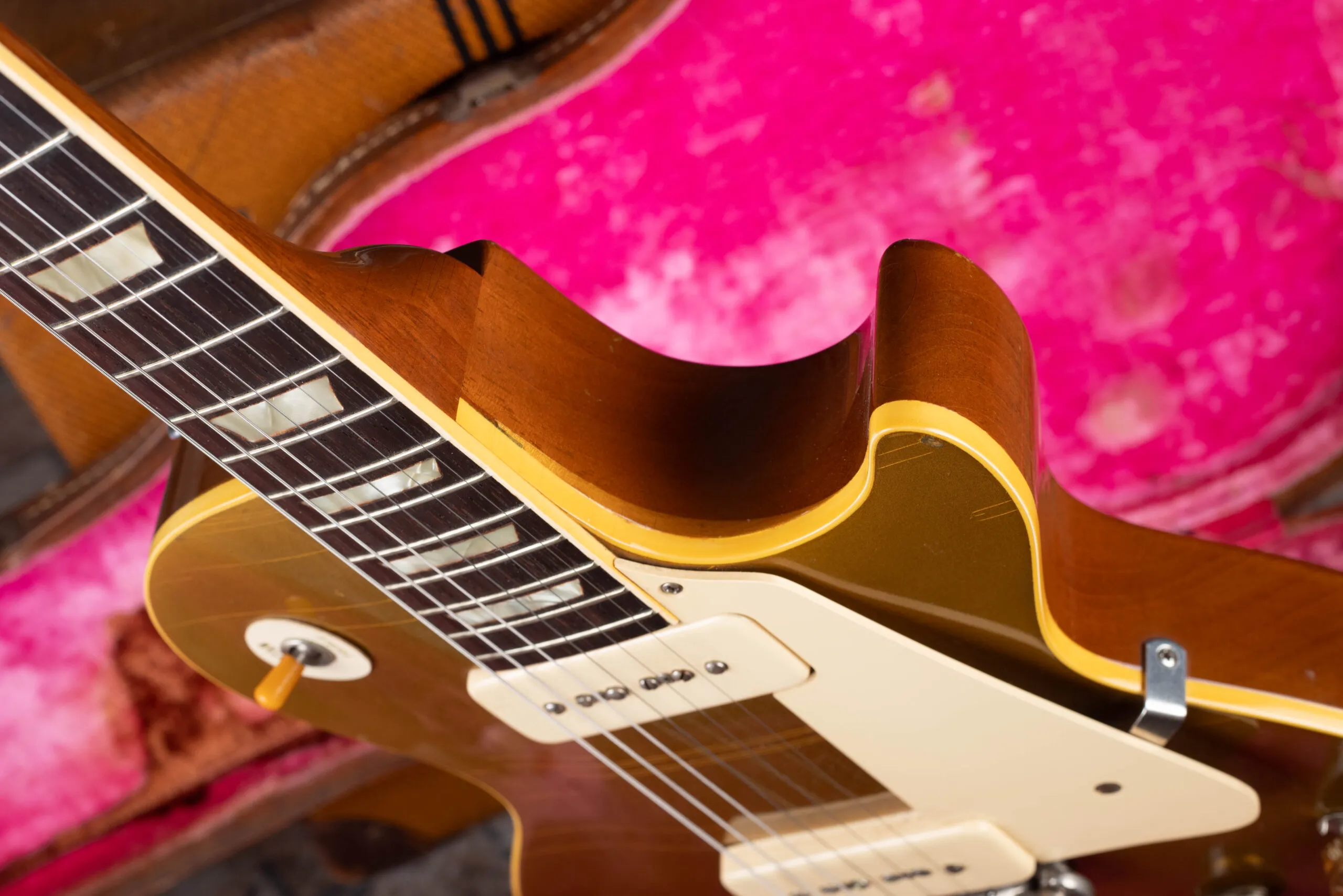 1954 Gibson Les Paul Goldtop maple top visible at cutaway edge behind cream binding, authentication detail showing carved maple cap beneath gold finish
