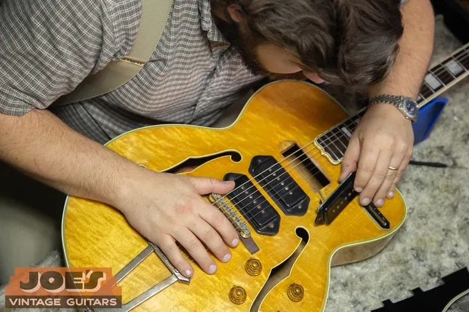 Joe’s Vintage Guitars specialist closely examining the top and binding of a 1956 Gibson ES-5 during an in-person appraisal