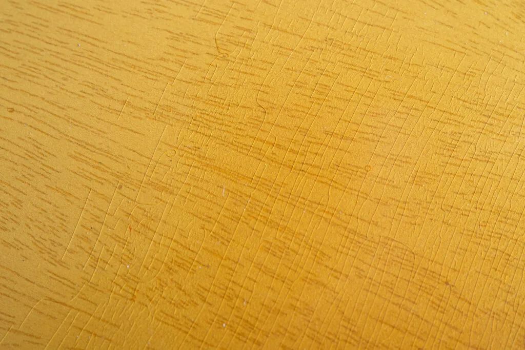 Close-up of a 1956 Gibson Les Paul Special in TV Yellow showing authentic “limed mahogany” finish. Detailed view of fine nitrocellulose lacquer weather checking, translucent wheat-colored tint, and white grain filler telegraphing through the mahogany body.