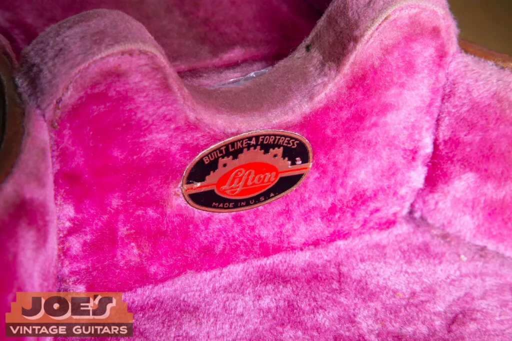 Macro close-up of the small metal Lifton brand plate on the exterior of a 1956 “California Girl” hardshell case.
