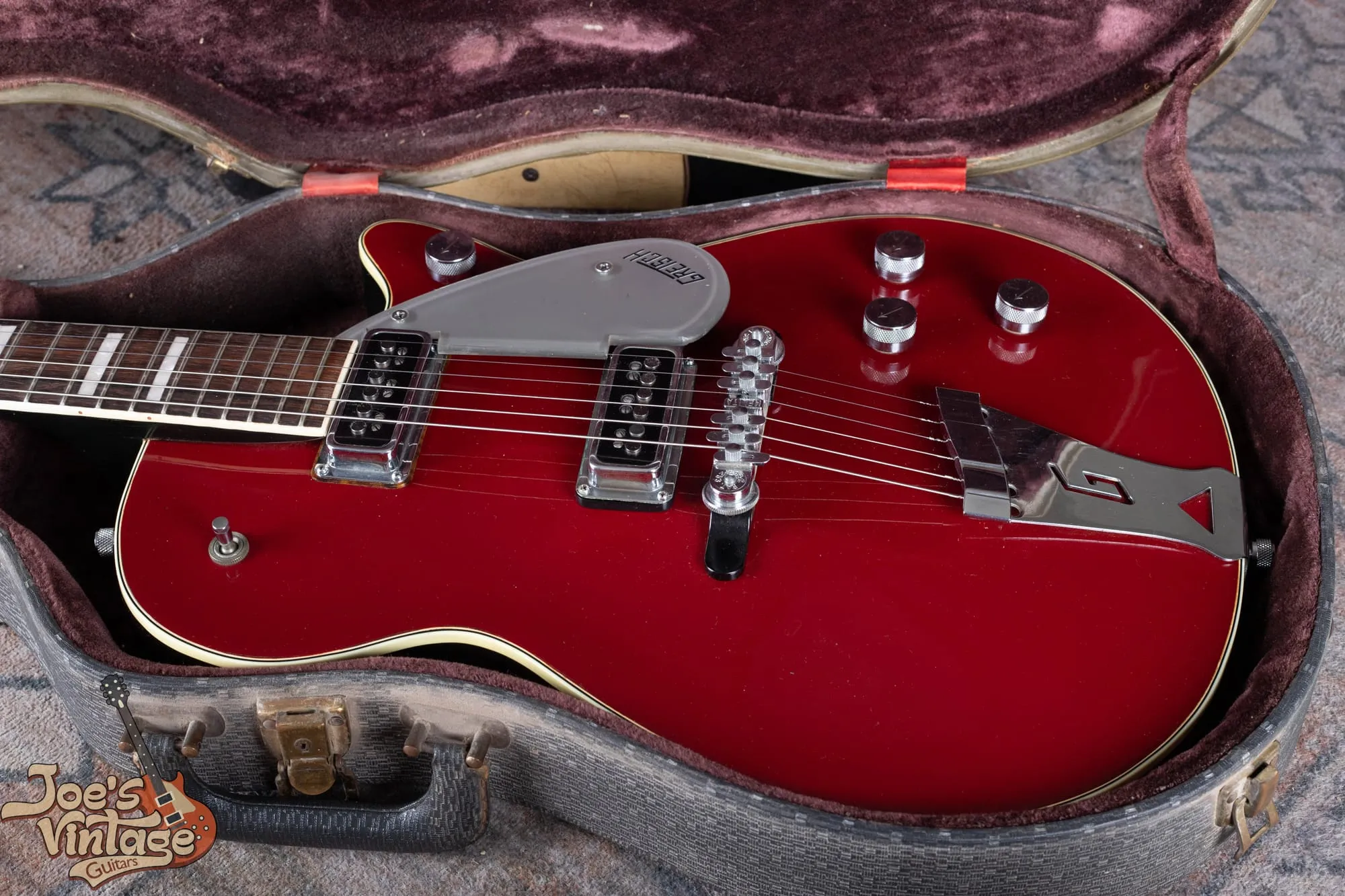 A 1956 Gretsch Jet Fire Bird lying in its original hardshell case with the case candy, viewed from above.
