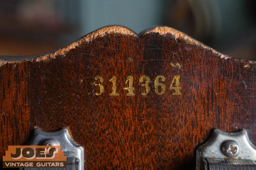 Macro close-up of a 1956 Gibson Les Paul serial number ink-stamped on the back of the headstock, showing the “6” prefix and the characteristic blocky mid-50s typeface.