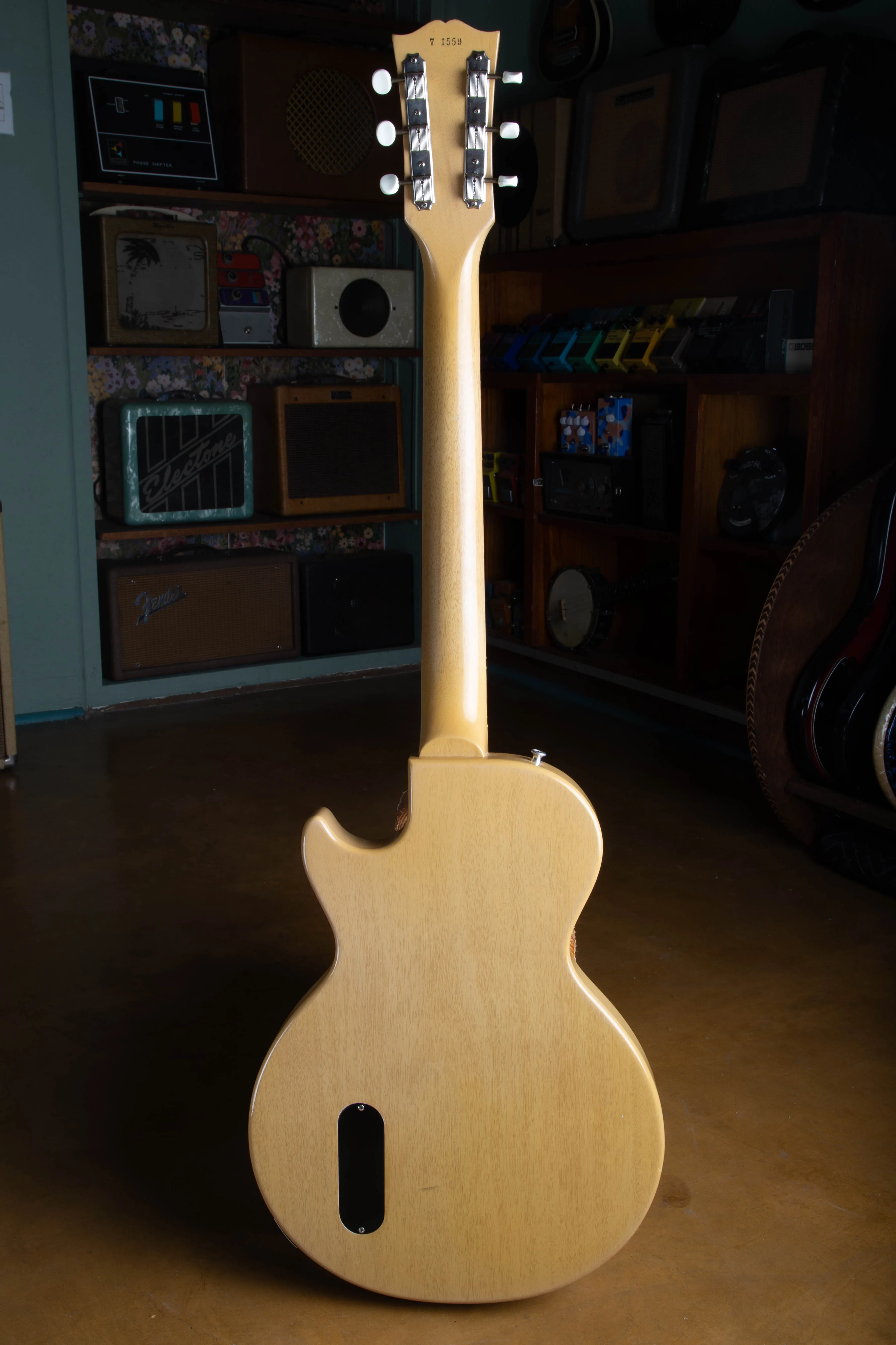 Back view of the full neck and headstock of a 1957 Gibson Les Paul TV Model, showing the one-piece mahogany neck, the back of the headstock with the ink-stamped serial number, the Kluson strip tuners, and the slab mahogany body in limed finish with its oval control cover.