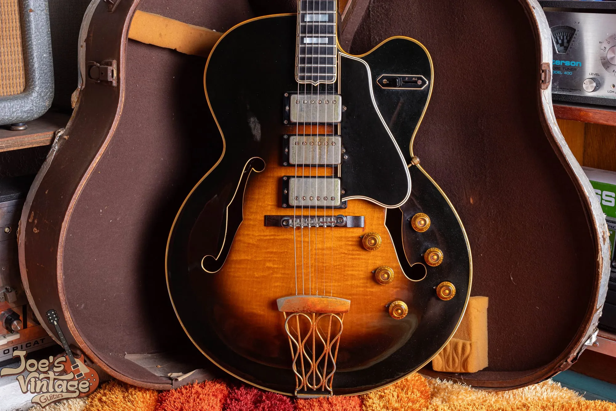 Front of a 1958 Gibson ES-5 Switchmaster in sunburst with three humbuckers, the four-way selector, and six gold knobs, in its case.