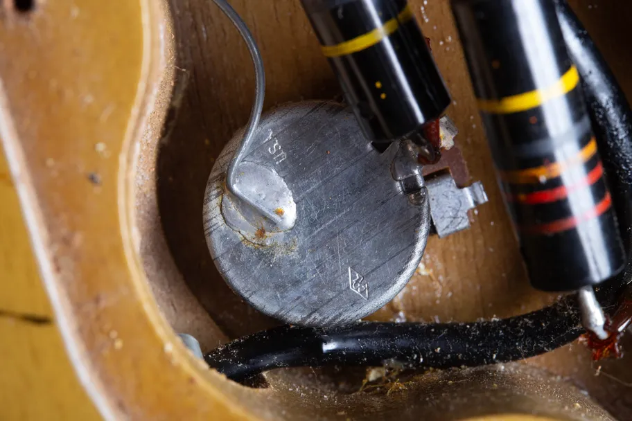 Close-up of an original 1958 Centralab (CRL) potentiometer inside a Gibson Les Paul Special control cavity, showing the stamped USA text and diamond CRL logo