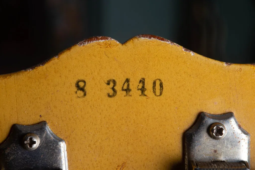 Detailed view of the back of a 1958 Gibson Les Paul Special headstock featuring the original black ink-stamped serial number. The Five-digit sequence is applied on top of the “TV Yellow” nitrocellulose finish, showing a distinct, slightly fuzzy edge characteristic of 1950s factory stamping rather than a modern impression into the wood.