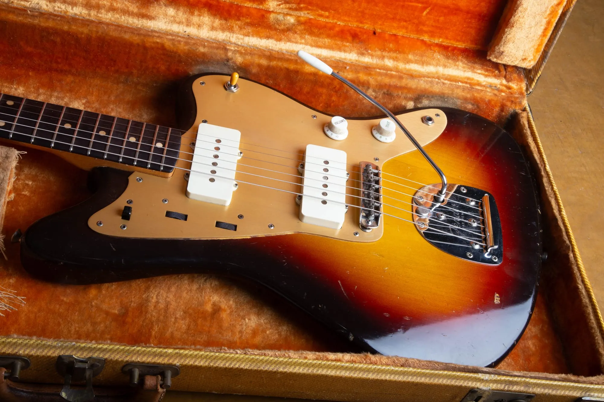 1959 Fender Jazzmaster with gold anodized guard lying in its original tweed case with orange plush lining, a complete first-year gold guard example