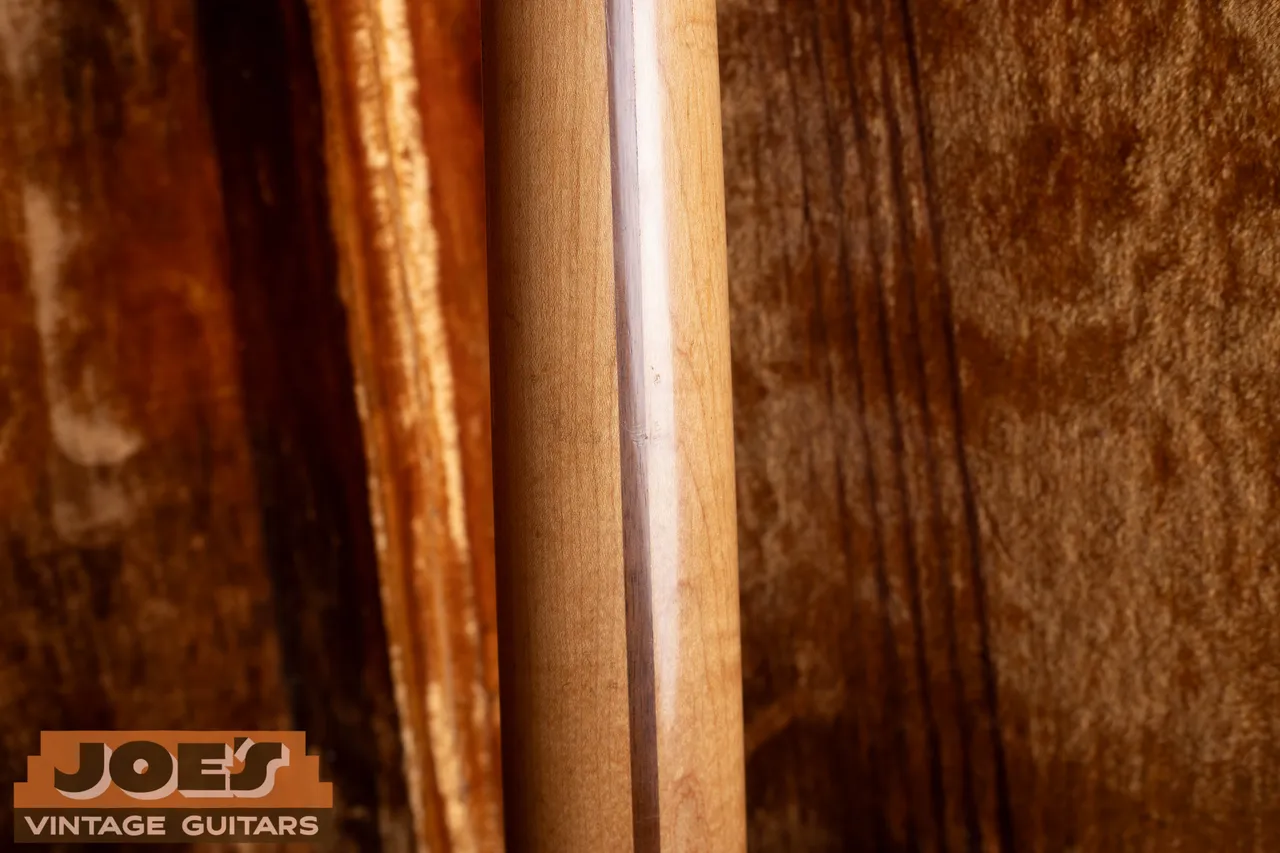 The back of a 1959 Fender Telecaster one-piece maple neck showing the dark walnut skunk stripe running down the center
