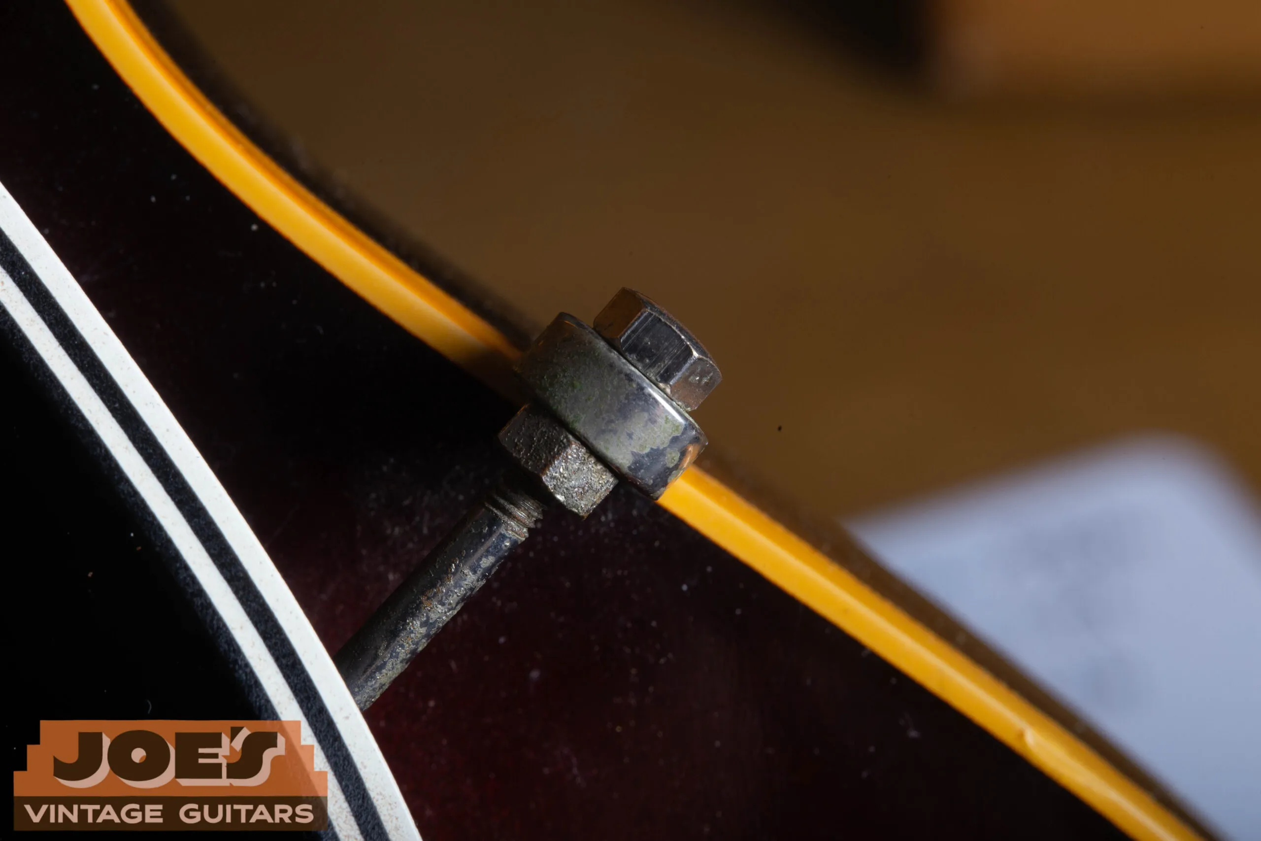 Pickguard mounting bracket detail on a 1959 Gibson ES-330, single-arm nickel bracket extending from the neck pickup area