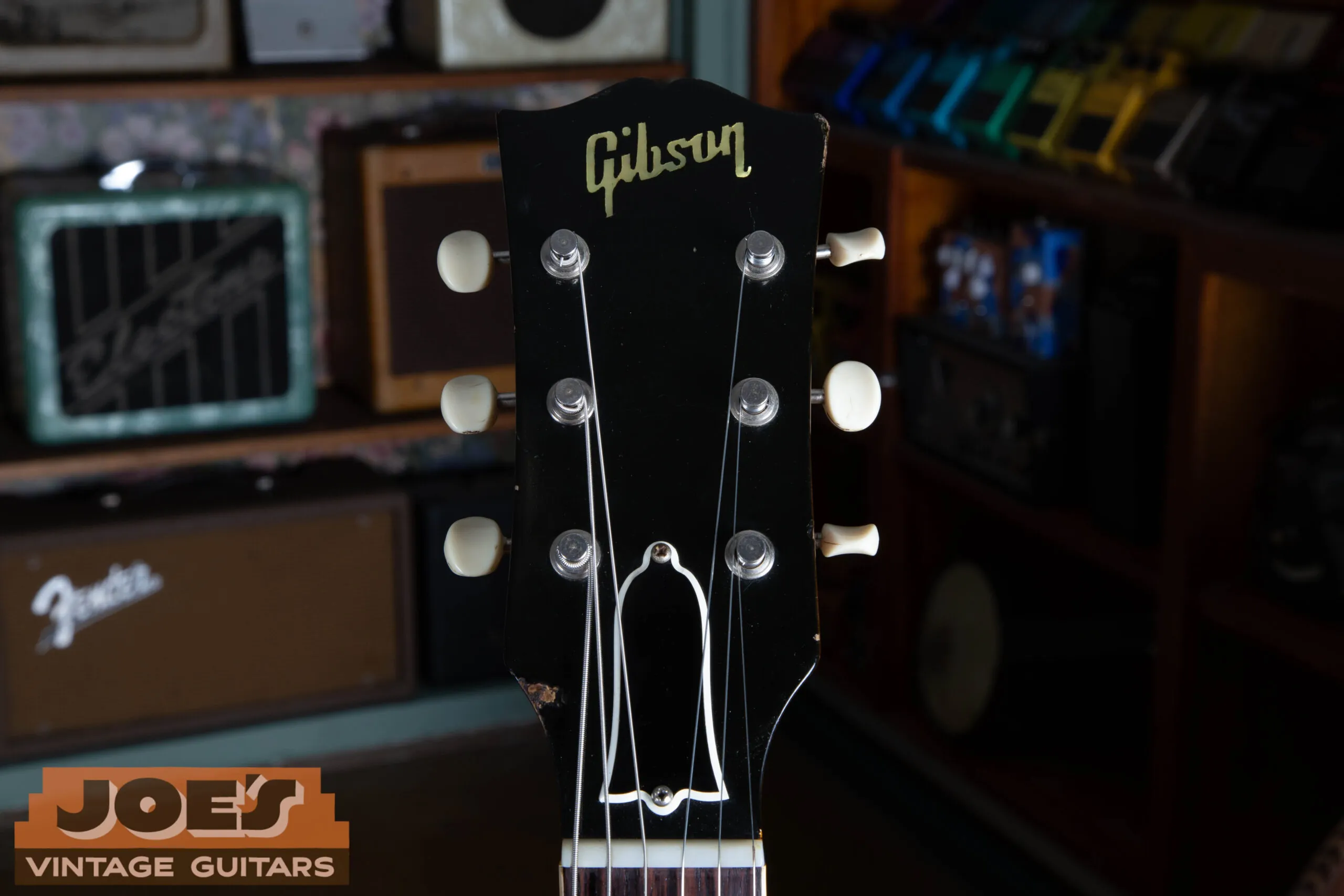 Front of headstock on a 1959 Gibson ES-330, plain unbound black face with pearl script logo and no crown inlay