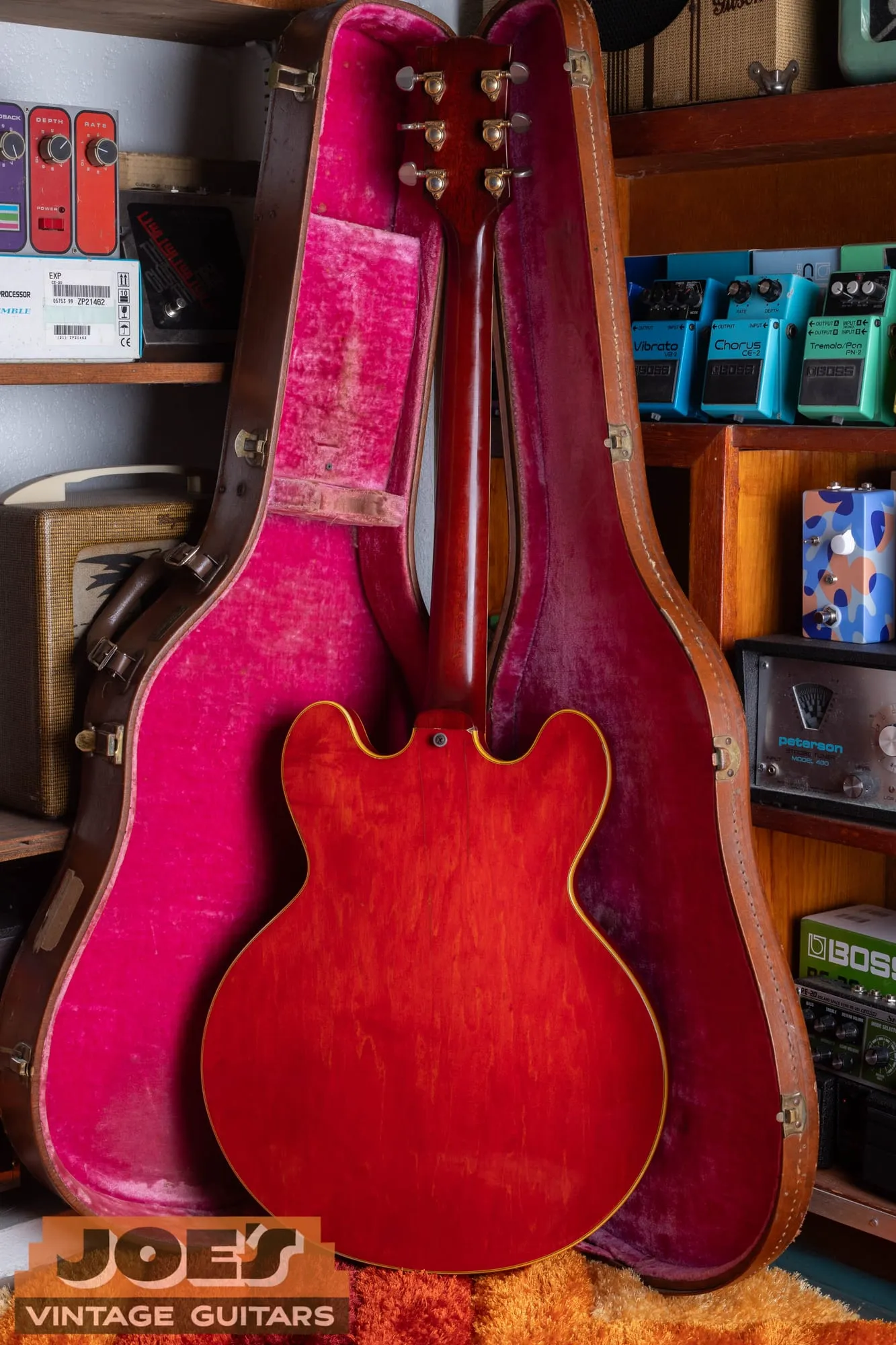Full back of a 1959 Gibson ES-355 and its headstock in the case, showing the plain cherry back of the neck with no volute.