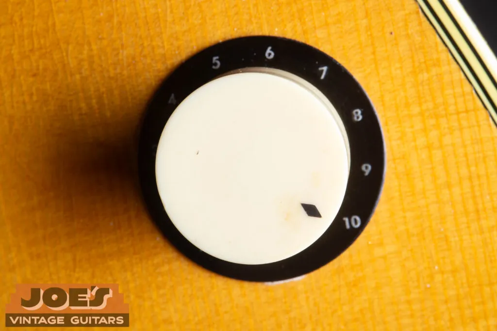 Close-up of a vintage white “cup” style control knob on a 1959 Martin D-28E, showcasing the original period-correct hardware and gold-plated components.