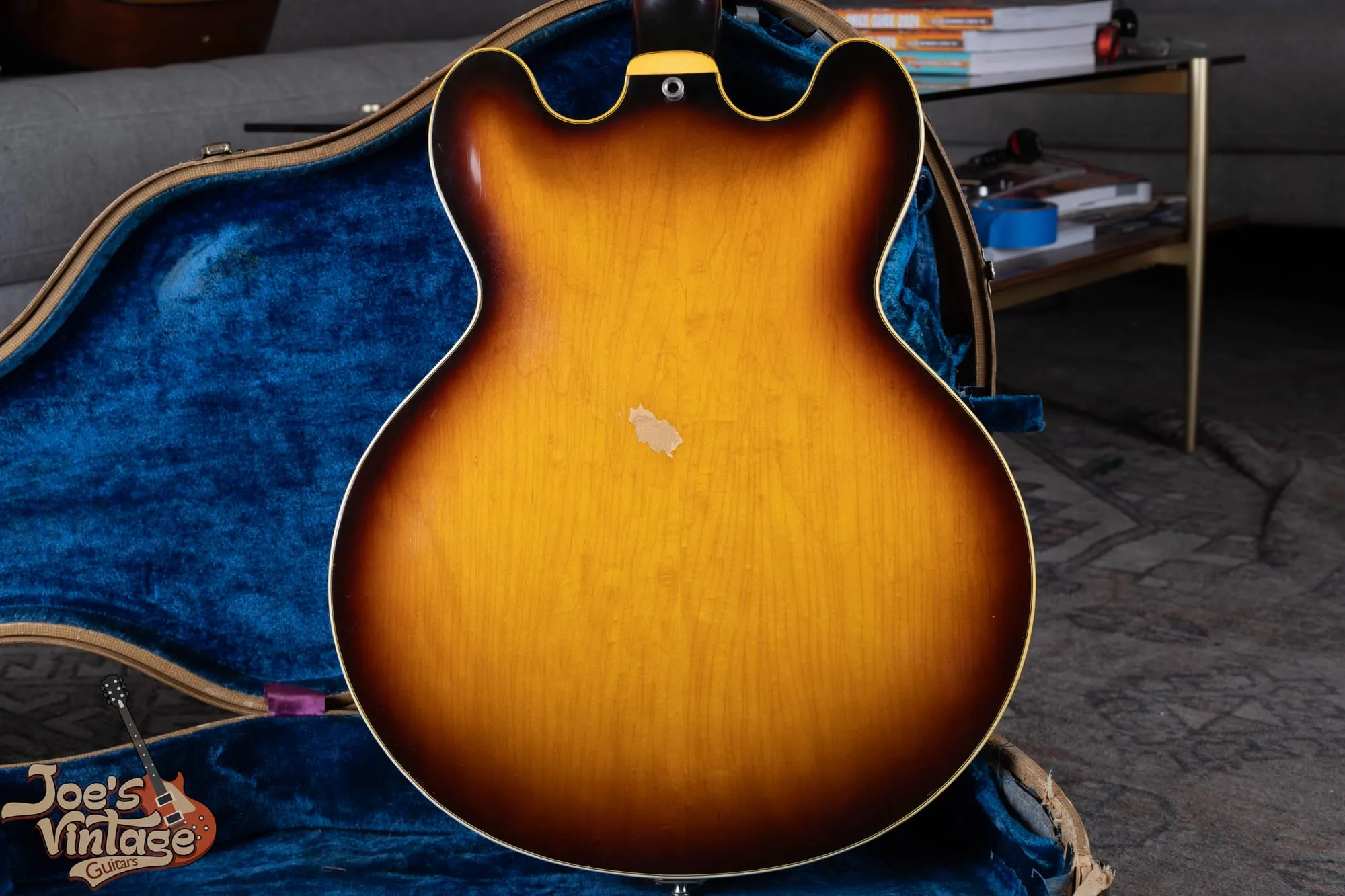 Front of a 1961 Epiphone Sheraton in sunburst with mini-humbucker pickups and a Bigsby vibrato, in its original blue-lined case.