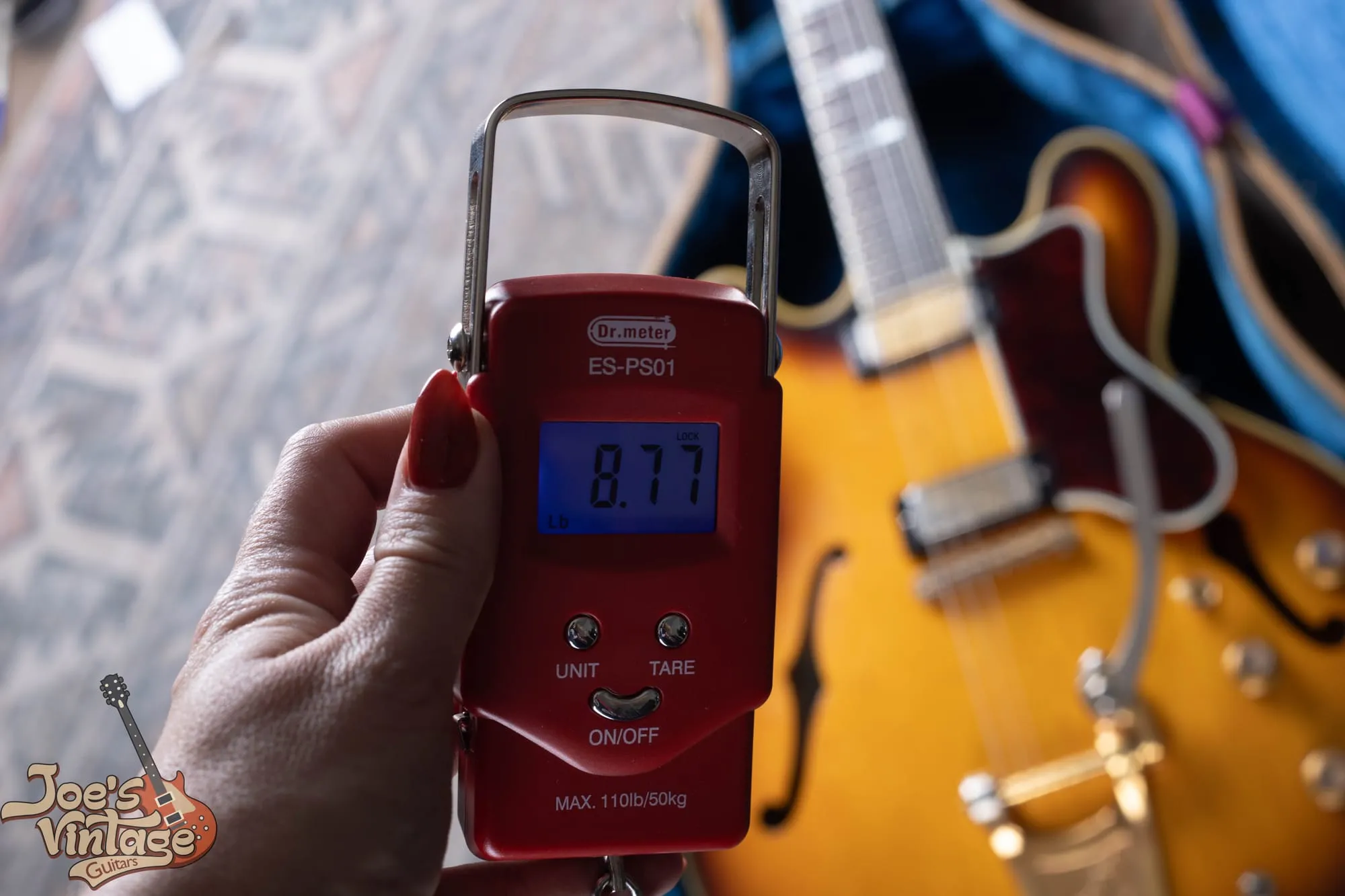 Digital scale showing a 1961 Epiphone Sheraton weighing 8.77 pounds.