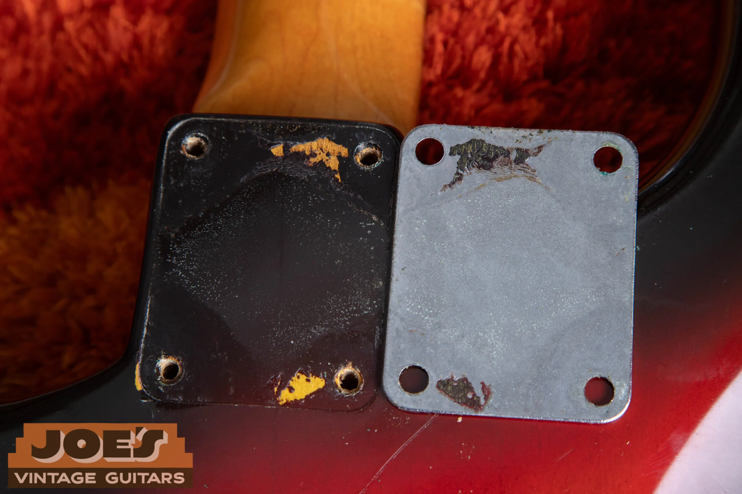 1962 Fender Stratocaster neck plate removed showing puzzle piece finish pattern, lacquer chips and wear along plate edge match the finish underneath confirming original unswapped plate