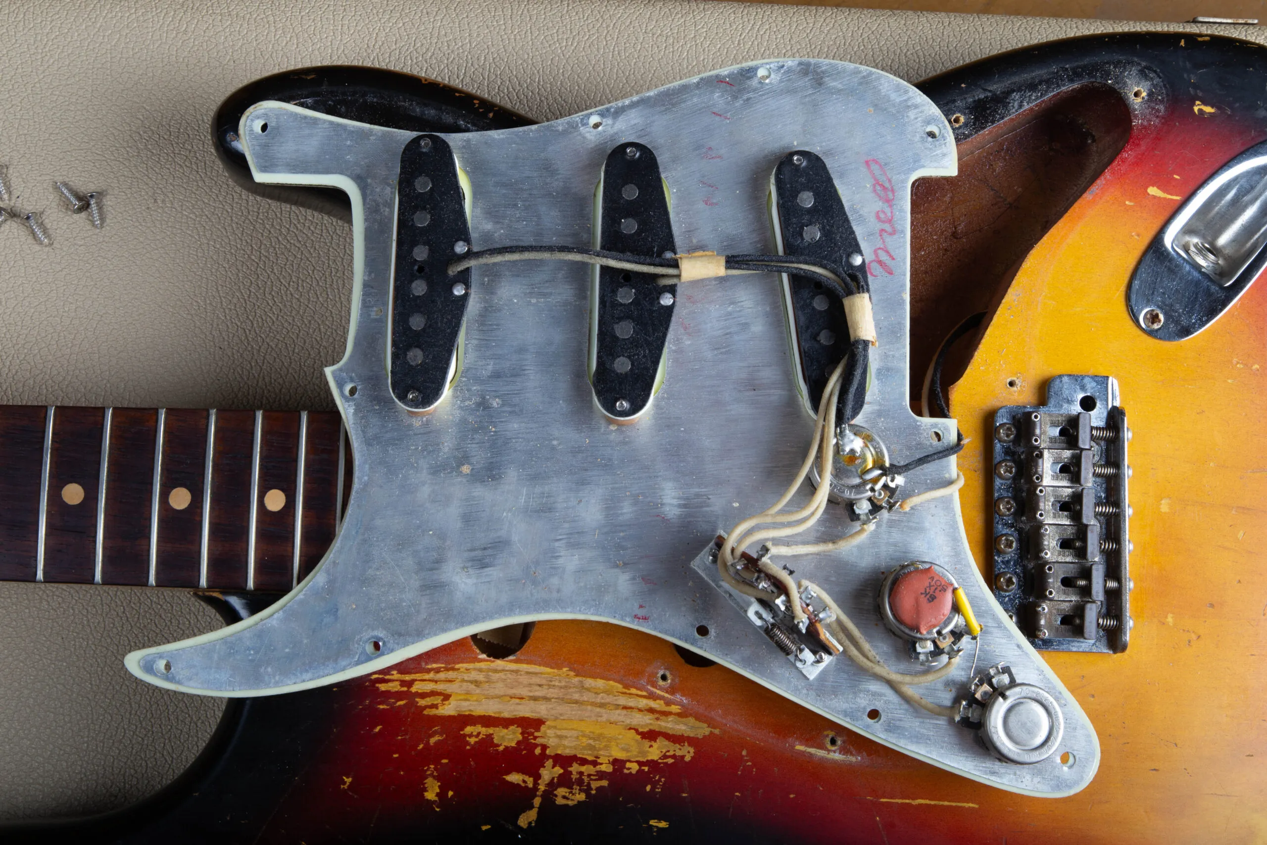 Back of the pickguard on a 1963 Fender Stratocaster showing aluminum shield, black bobbin pickups, and original wiring