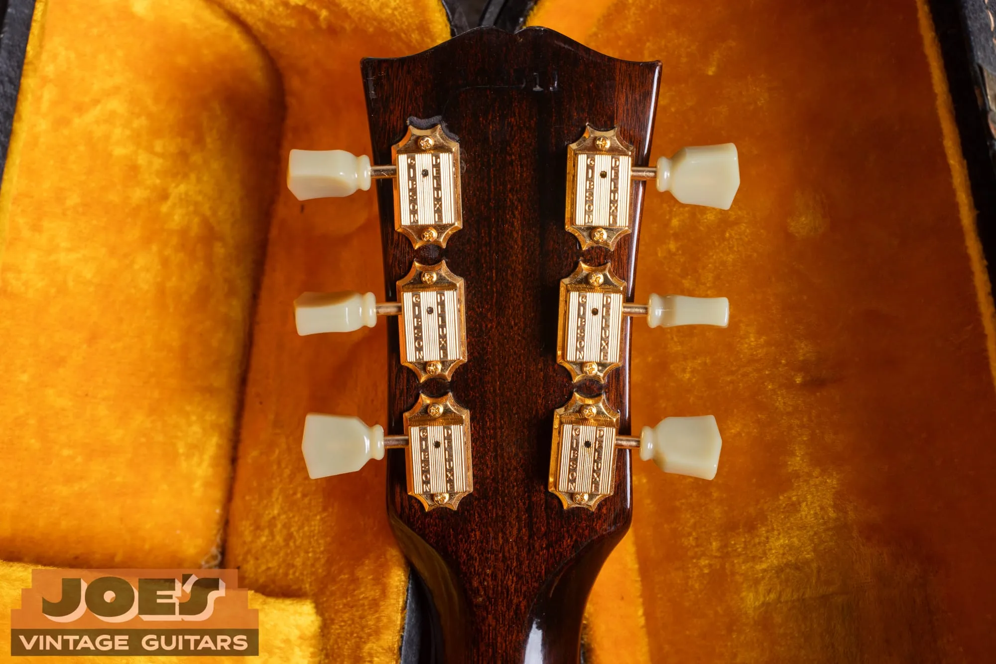 The back of the headstock of a 1963 Gibson ES-345 showing gold Gibson Deluxe tuners with single-ring tulip buttons.