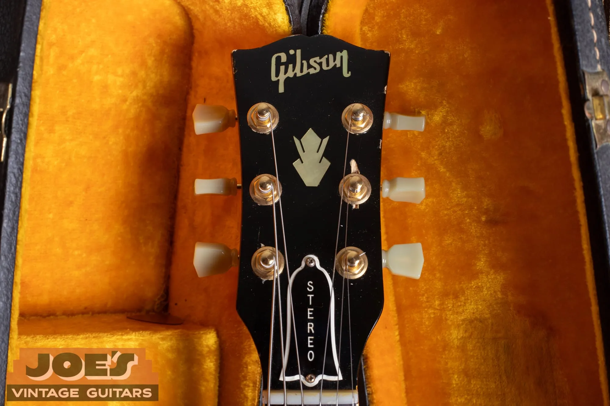 The headstock of a 1963 Gibson ES-345 showing the Gibson logo, pearl crown inlay, and a truss-rod cover engraved STEREO.