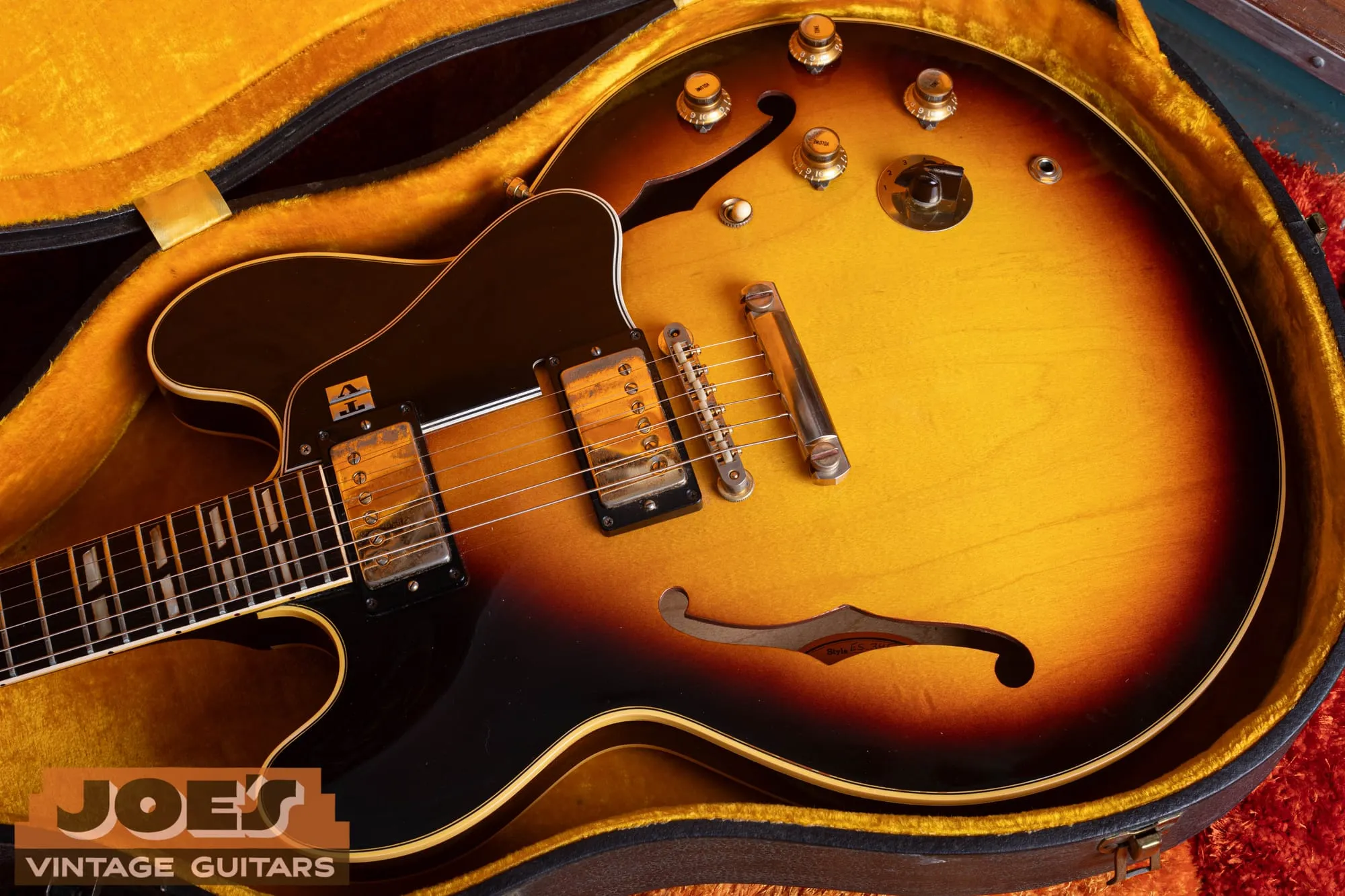 The control layout of a 1963 Gibson ES-345 in sunburst: two volume knobs, two tone knobs, a six-position Varitone rotary, a stereo output jack, and a gold stop-bar tailpiece.