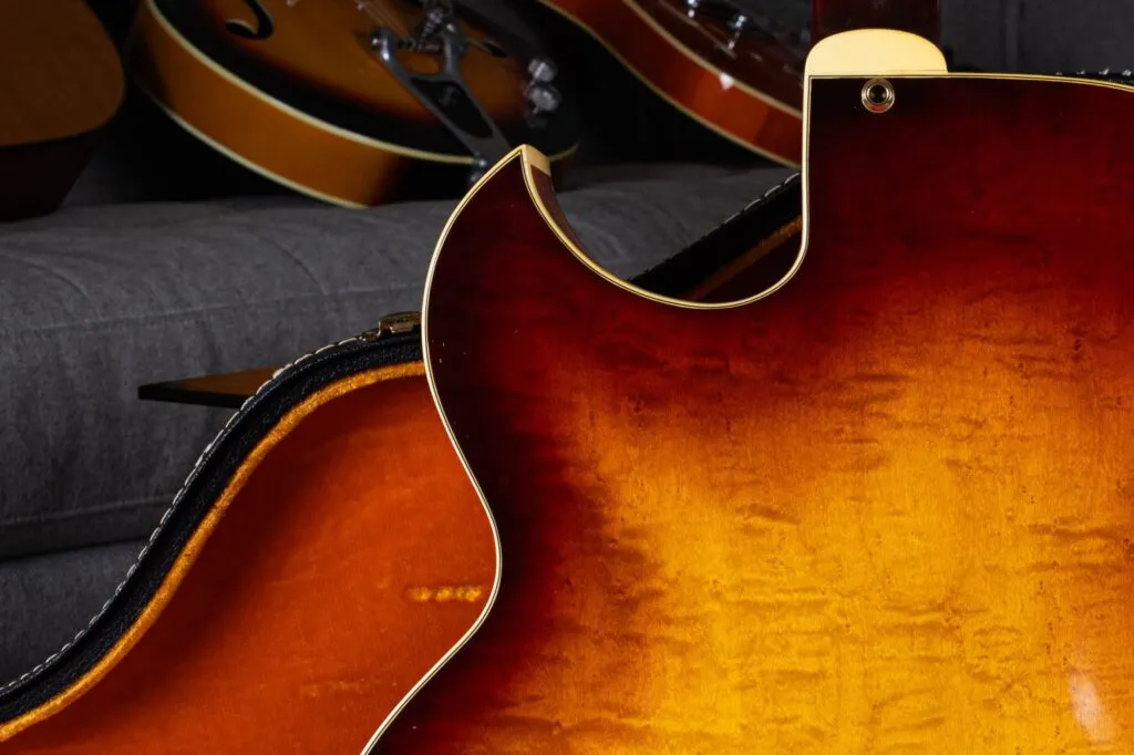 Close-up of the sharp Florentine cutaway on a 1964 Gibson L-5 archtop guitar in a sunburst finish. The image showcases the elegant flamed maple back, multi-ply binding, and the graceful curve that defines this era of Gibson’s flagship model.