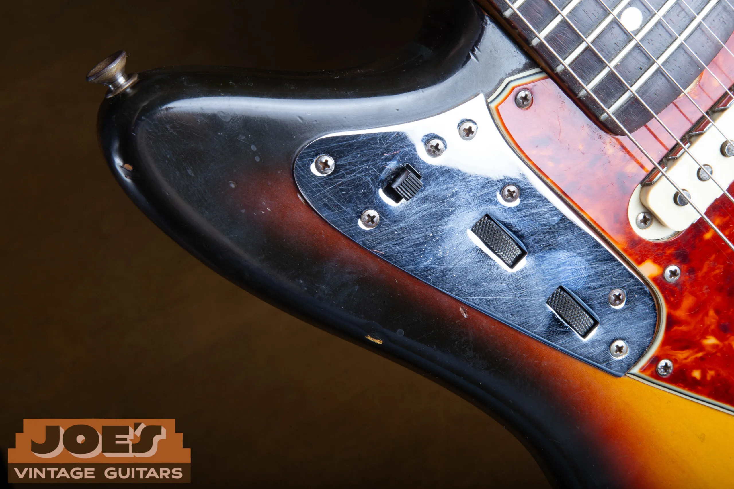 Upper bout rhythm circuit slider switch and volume and tone roller knobs on a 1965 Fender Jaguar