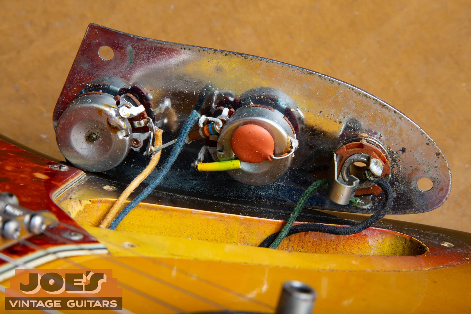 The original wiring harness of a 1965 Fender Jaguar, showing clean factory solder joints with flux around the edges, cloth covered wire, and a period capacitor