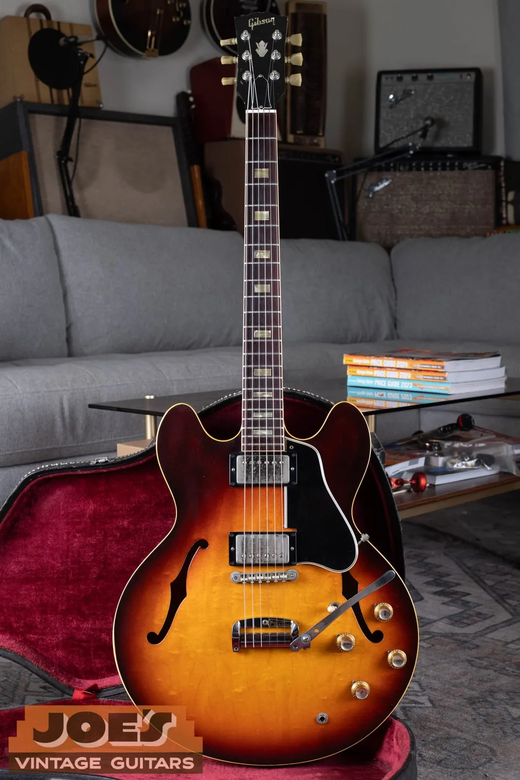 1965 Gibson ES-335 sunburst full front view standing in its case, factory short Maestro Vibrola visible at the tailpiece