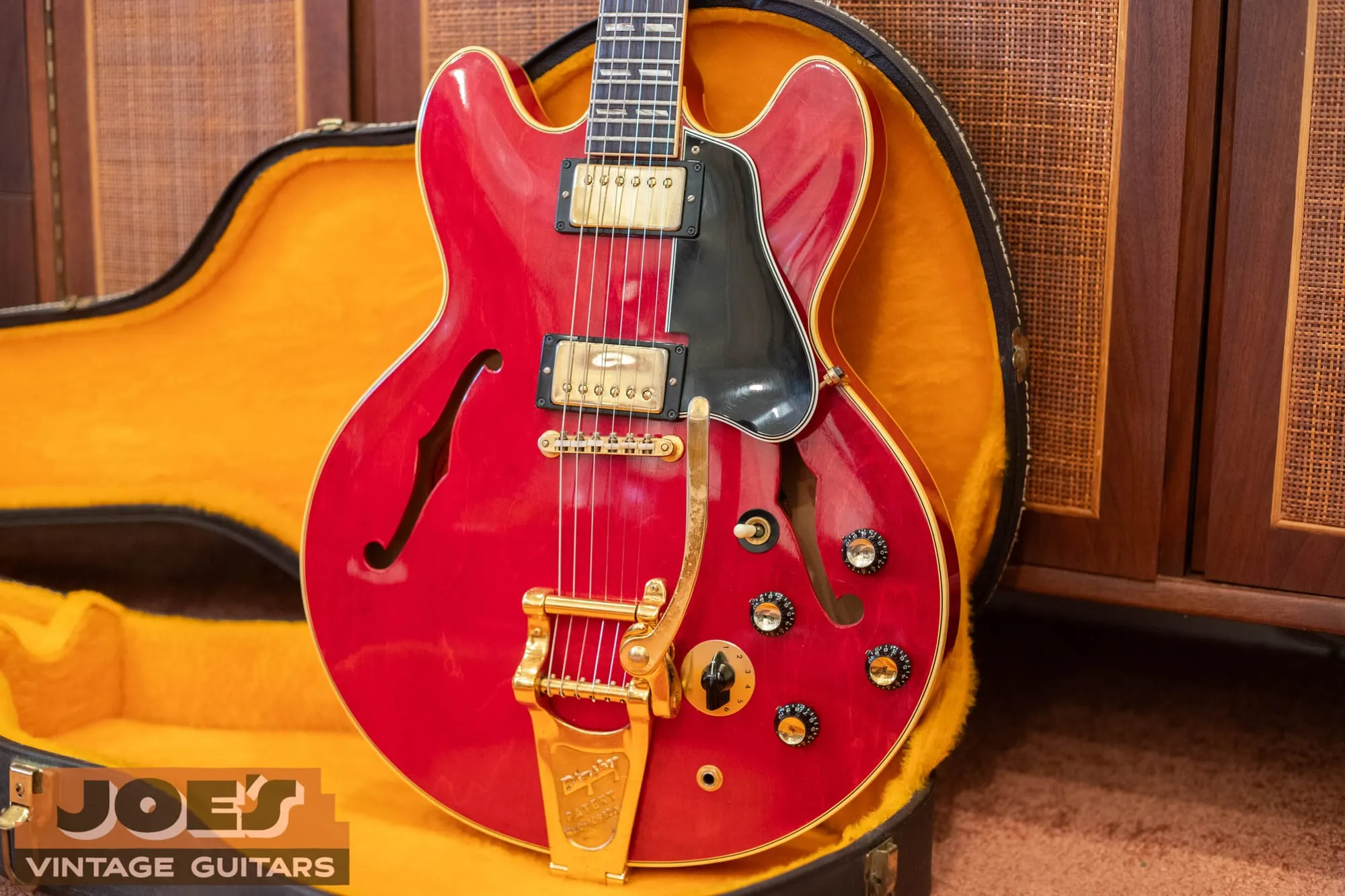A 1966 Gibson ES-345TDC in cherry red with gold hardware and a gold Bigsby vibrato, shown from the front in its case.