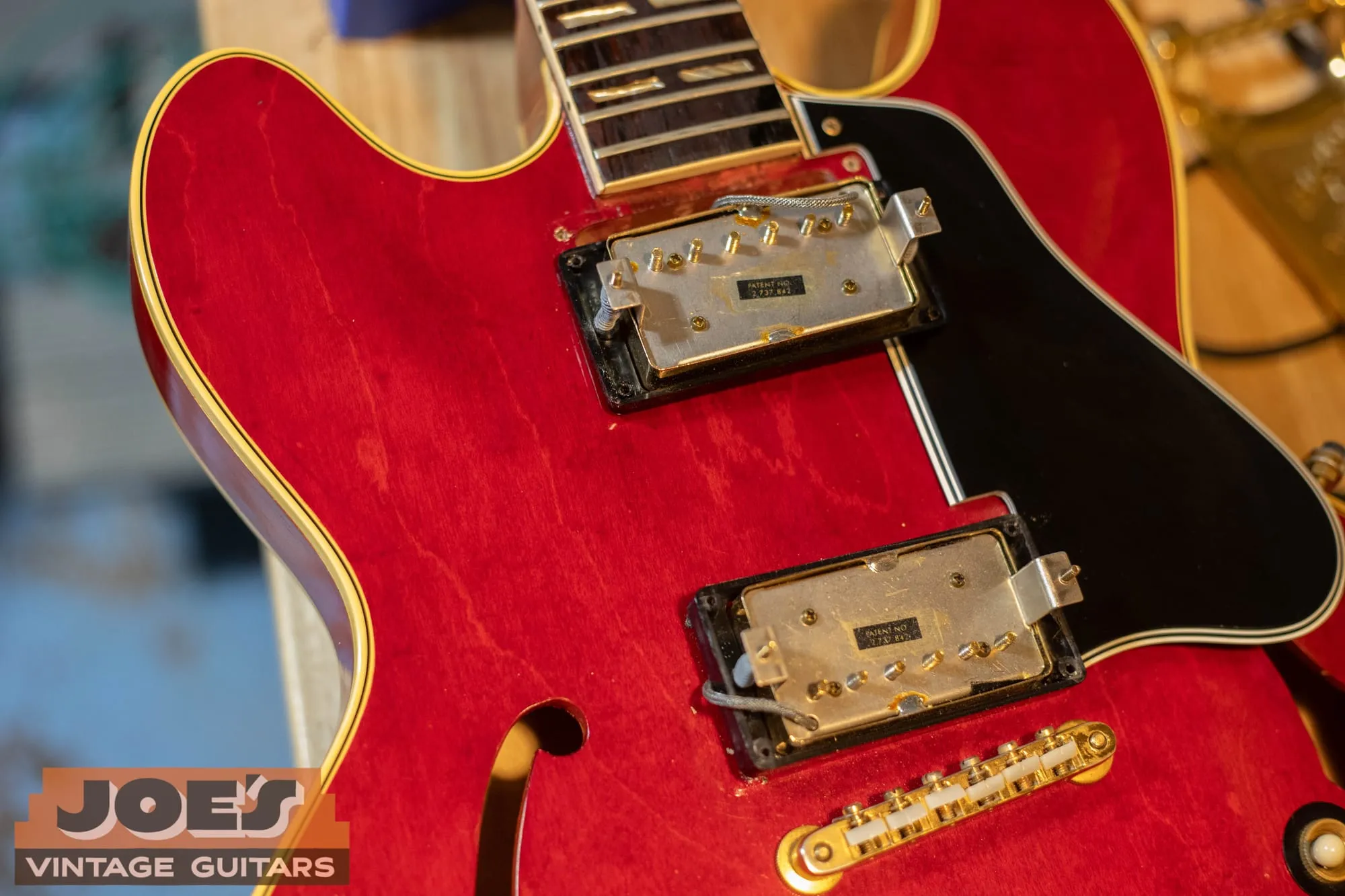 The two pickups, gold ABR-1 bridge, and black pickguard of a 1966 Gibson ES-345 in cherry.