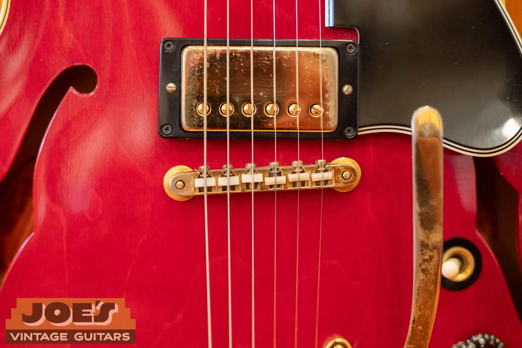 Close-up of a gold-covered Patent Number humbucker and gold ABR-1 bridge on a 1966 Gibson ES-345 in cherry.