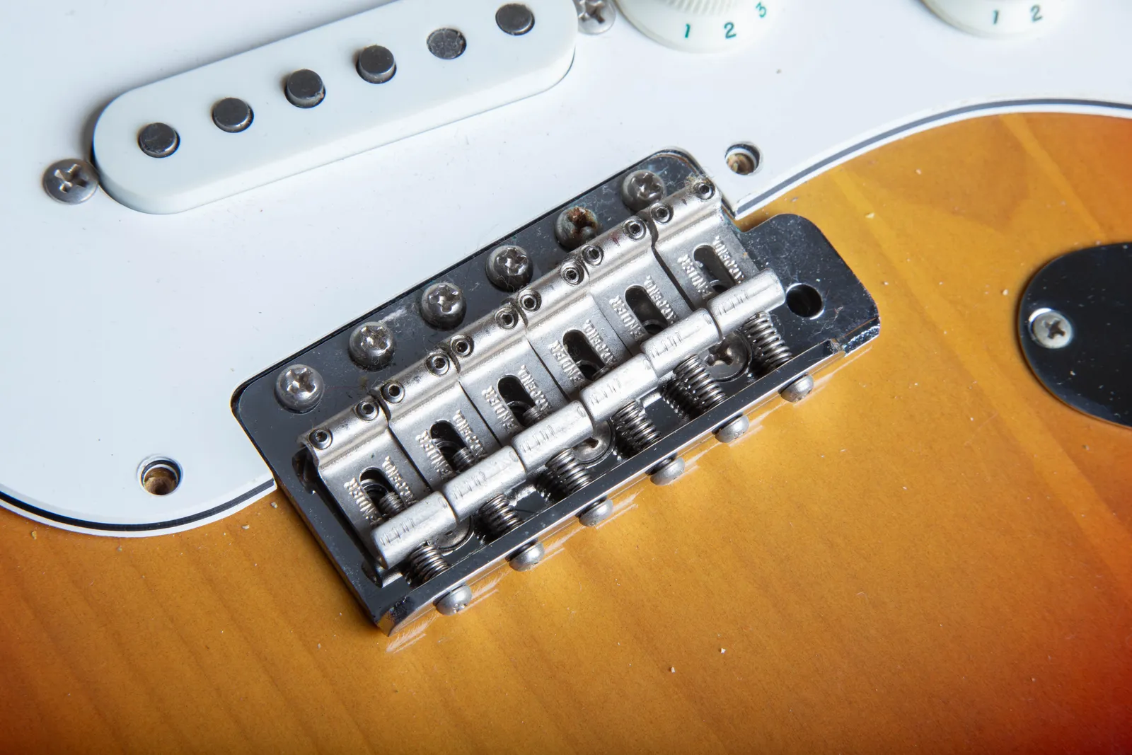 The bridge of a 1967 Fender Stratocaster, showing stamped steel saddles marked FENDER PAT. PEND.