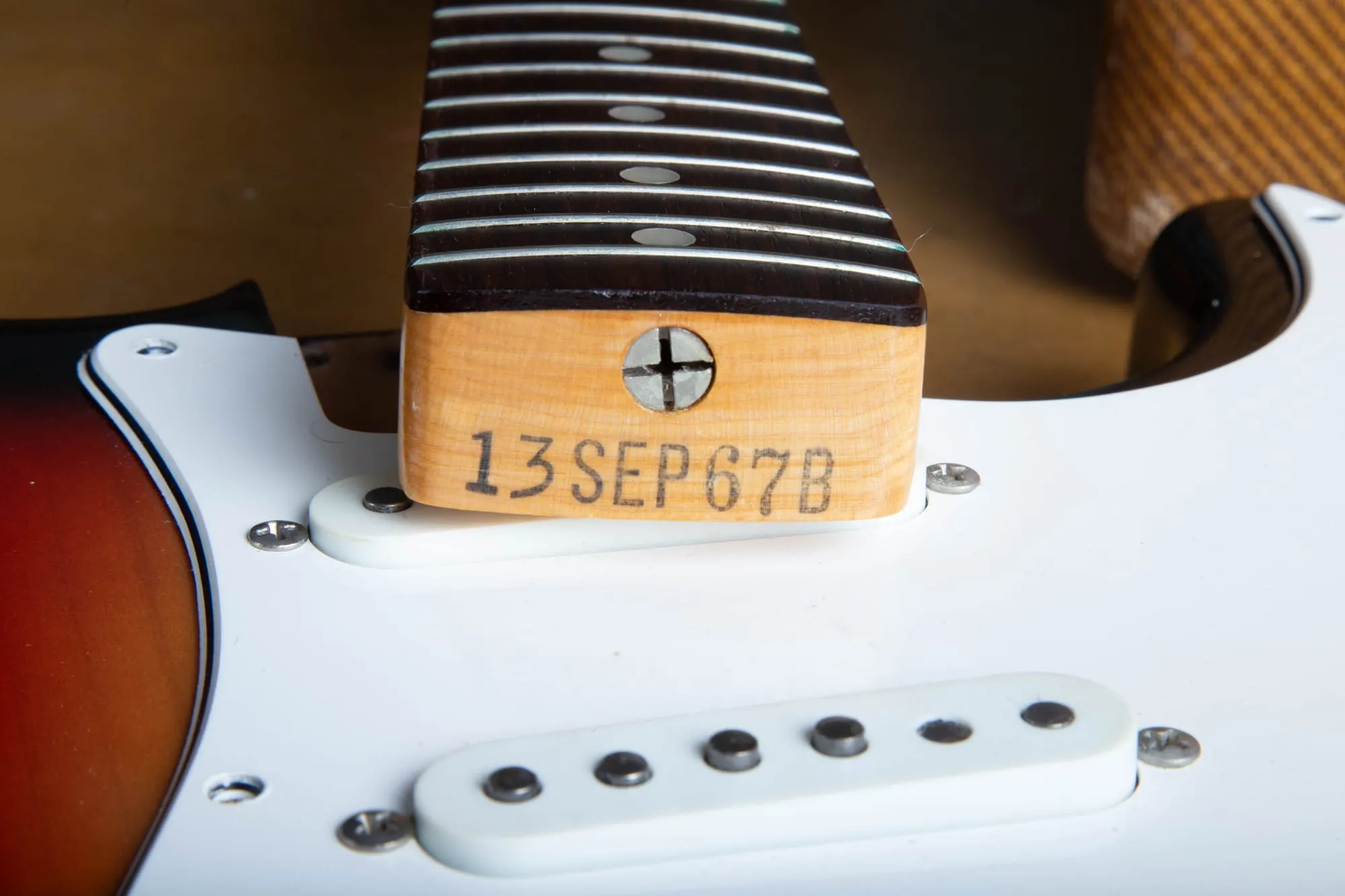 Neck heel of a 1967 Fender Stratocaster stamped 13 SEP 67 B in black ink, seen with the neck bolted into the body between the middle and bridge pickup routes.