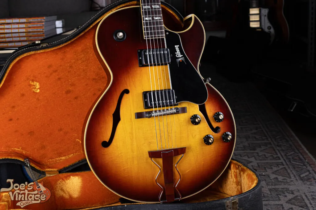 Shot of a 1968 Gibson ES-175D in Sunburst finish with two humbuckers, featuring a rare gold ‘Gibson’ logo on the pickguard and an original bridge with nylon saddles.