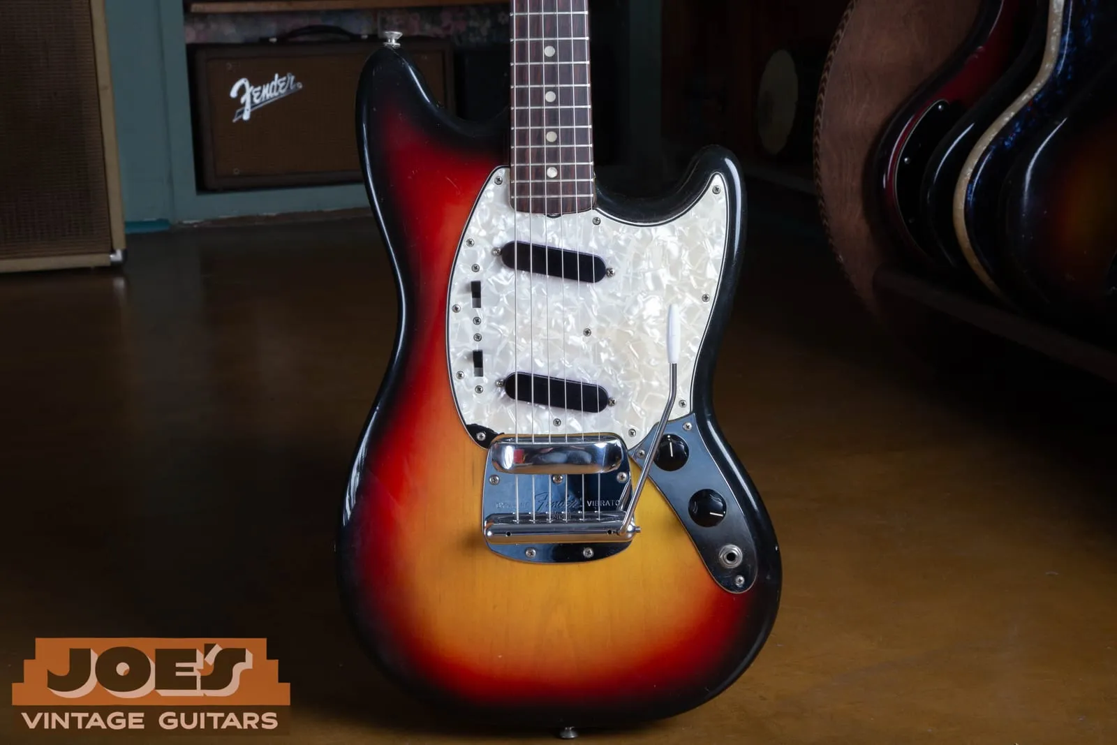 Front of a 1972 Fender Mustang in three-color sunburst with a pearloid pickguard and the Dynamic Vibrato.