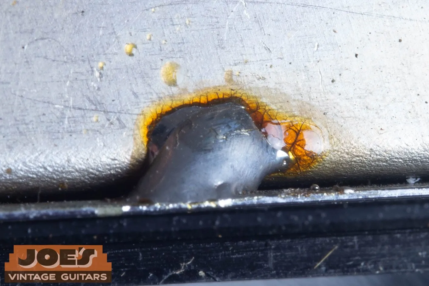Dull grey factory solder joint with aged amber flux on vintage guitar electronics