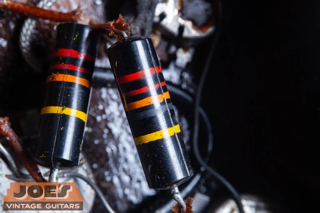 An internal view of the 1957 control cavity showing the original Sprague “Bumblebee” capacitors with their iconic color-coded stripes and .022uF 400V ratings.