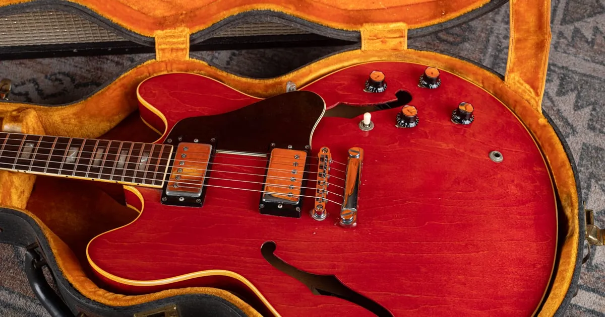 A cherry red Gibson ES-335 resting in its case, representative of the vintage guitars Cardinal Vintage Guitars buys across Ohio and the Midwest.
