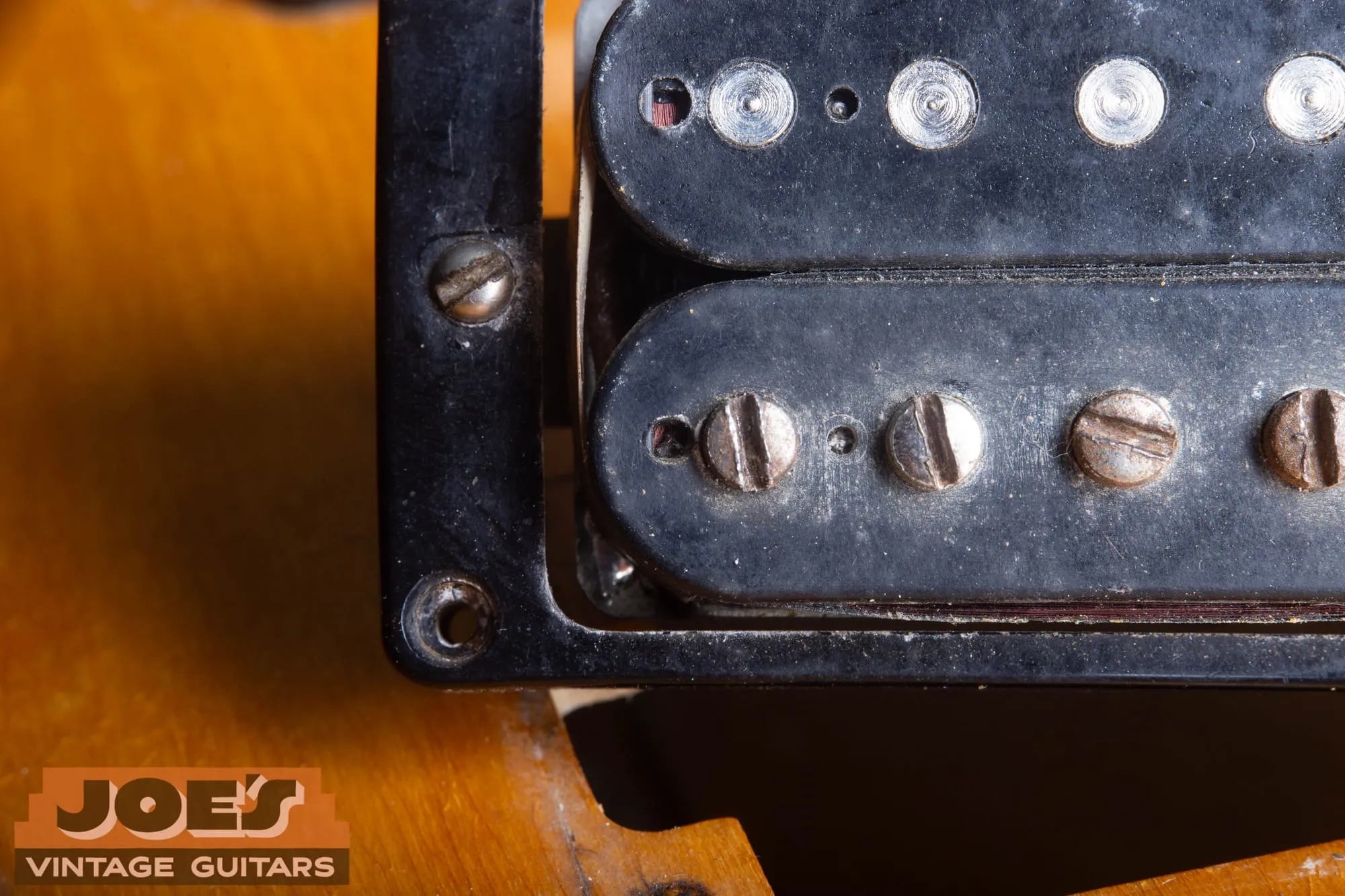 Uncovered Gibson humbucker showing the square tooling hole with the molded circle around it on the slug bobbin.