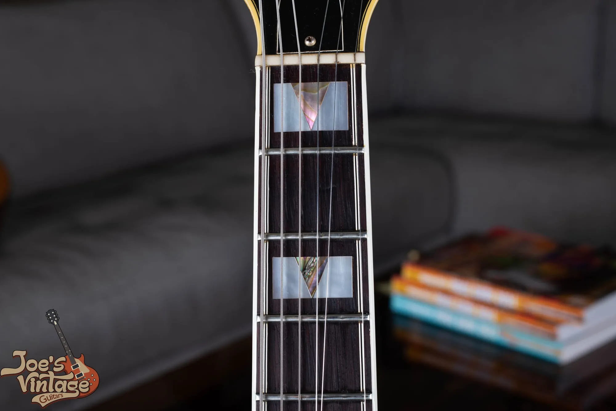 Bound rosewood fingerboard of a vintage Epiphone Sheraton showing large pearl block-and-triangle inlays.