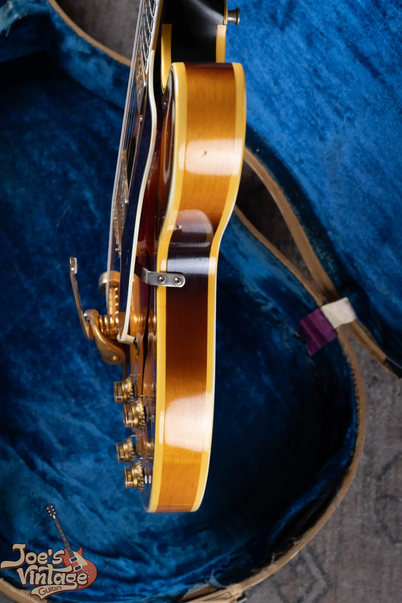 Full front of a 1961 Epiphone Sheraton showing the double rounded cutaways, sunburst laminated maple top, f-holes, and pickguard.