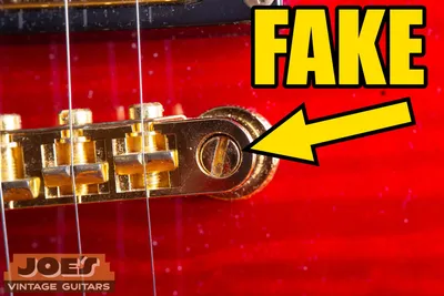 Fake Gibson bridge sitting on chunky bolts with a flathead screwdriver slot on top, a counterfeit sign