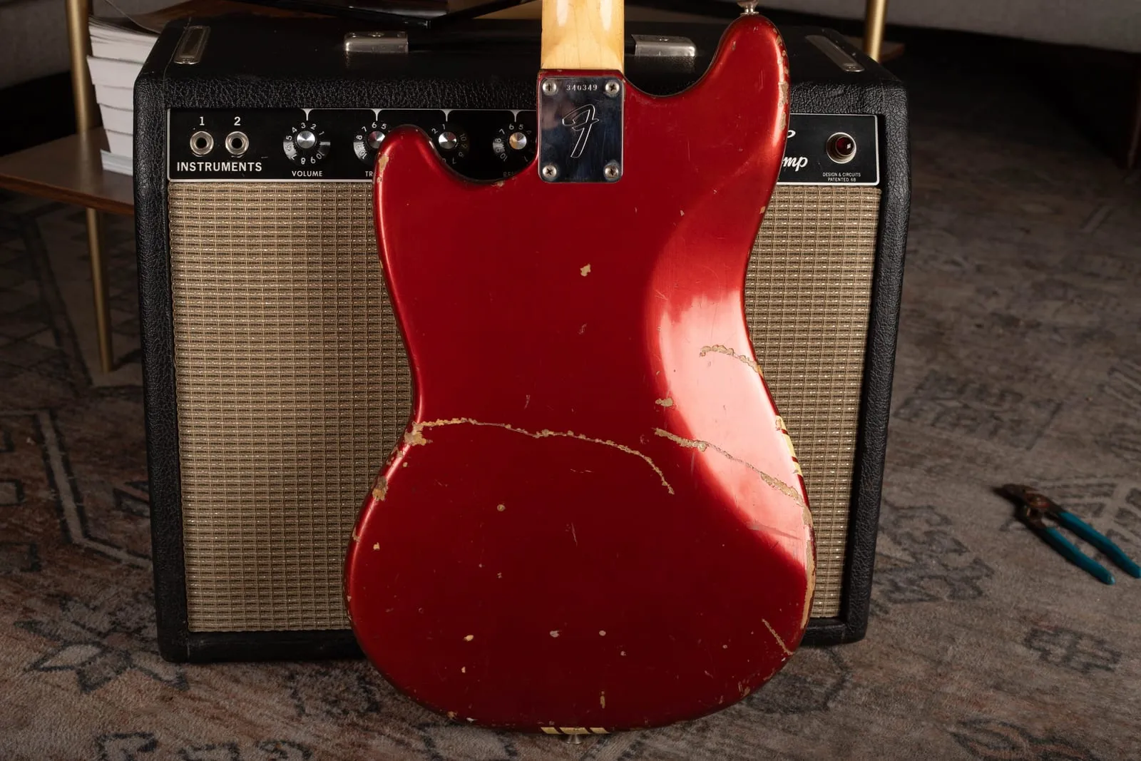 The back of a Competition Red Fender Mustang showing plain red with no racing stripe, heavy player wear, and an F neck plate stamped 340349