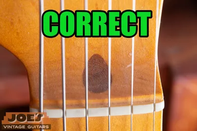 Genuine dark walnut truss rod plug on a vintage Fender neck, a reliable real-Fender identifier