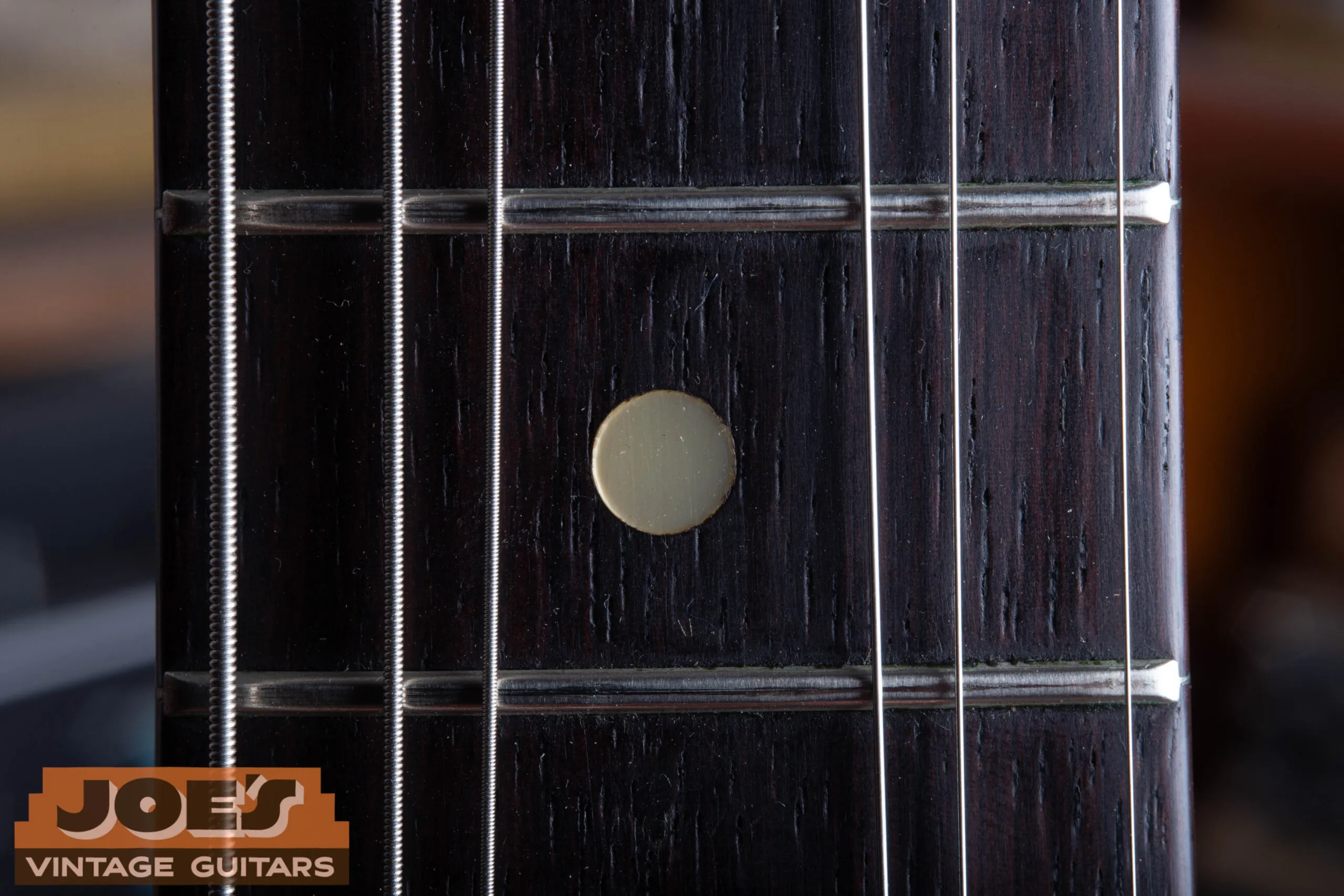Fender Jazzmaster pearloid dot fingerboard inlay close-up, bright reflective pearl dot used late 1964 through mid 1966, transition era Jazzmaster indicator