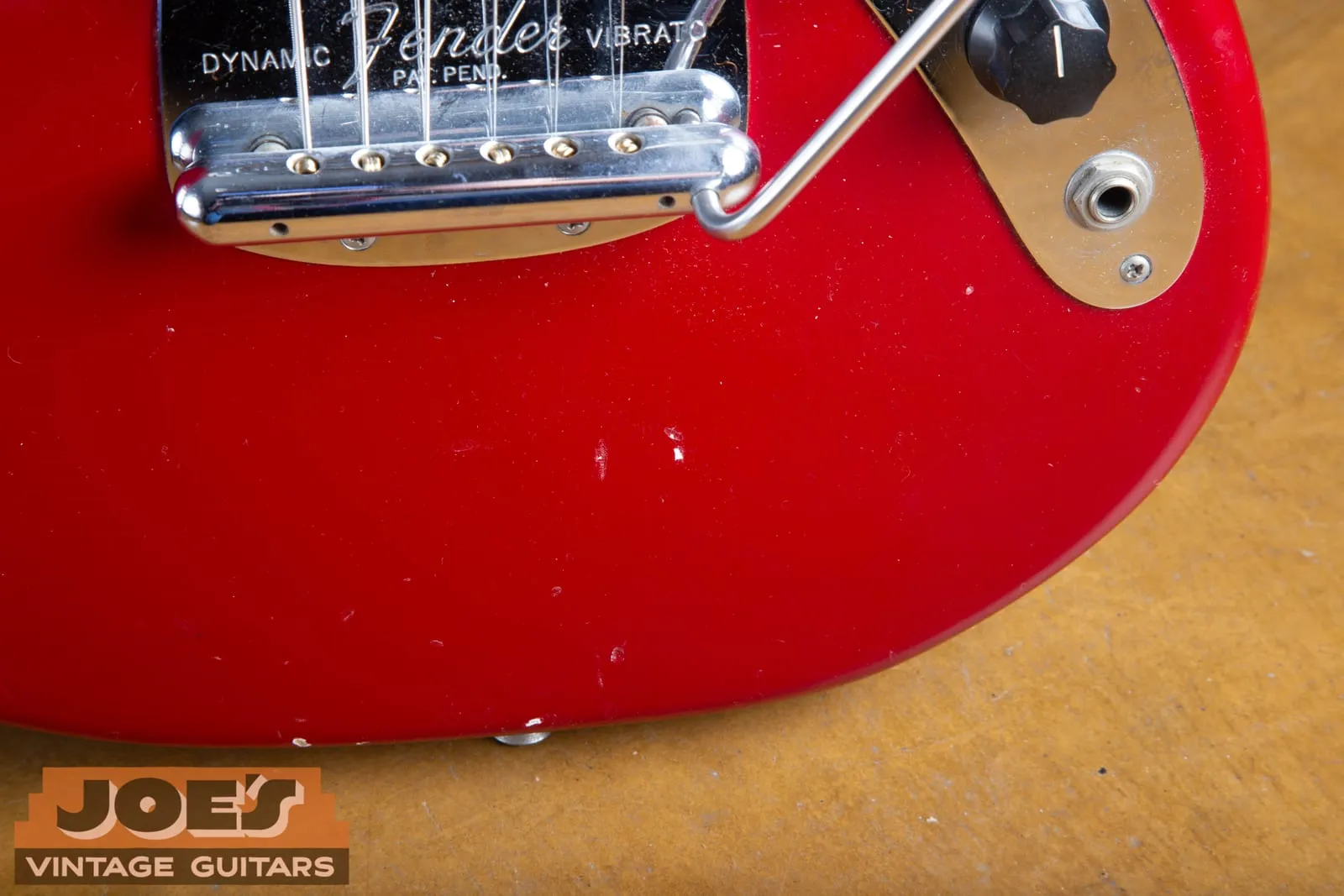 Close-up of the chrome Fender Dynamic Vibrato bridge and tailpiece on a 1965 Mustang, engraved Fender Dynamic Vibrato Pat. Pend.